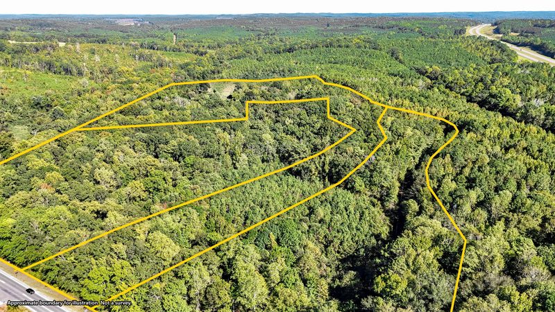 Aerial photo of wooded acreage with the approximate property boundary drawn on in yellow, captioned not a survey
