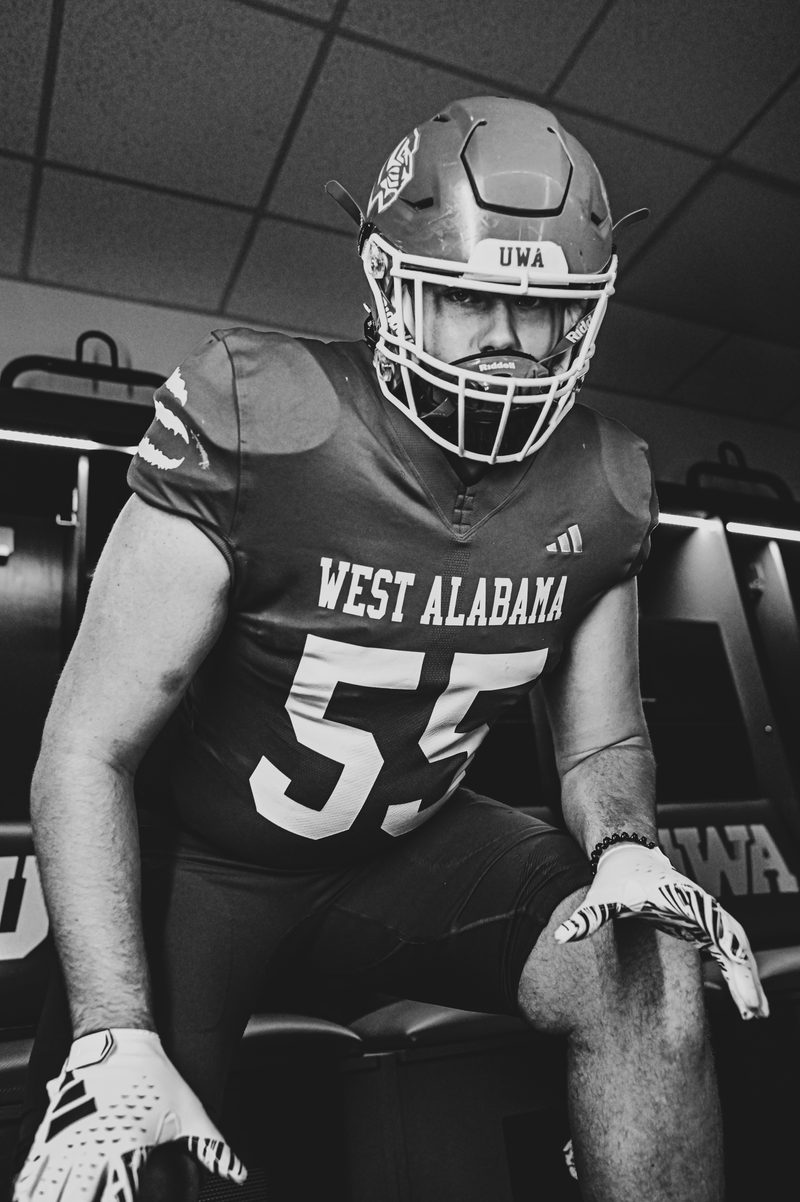 Black and white portrait of a West Alabama player number 55 seated in the locker room