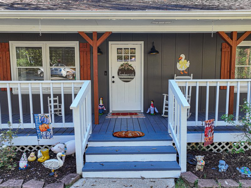 Front porch steps and a white door framed by cedar posts